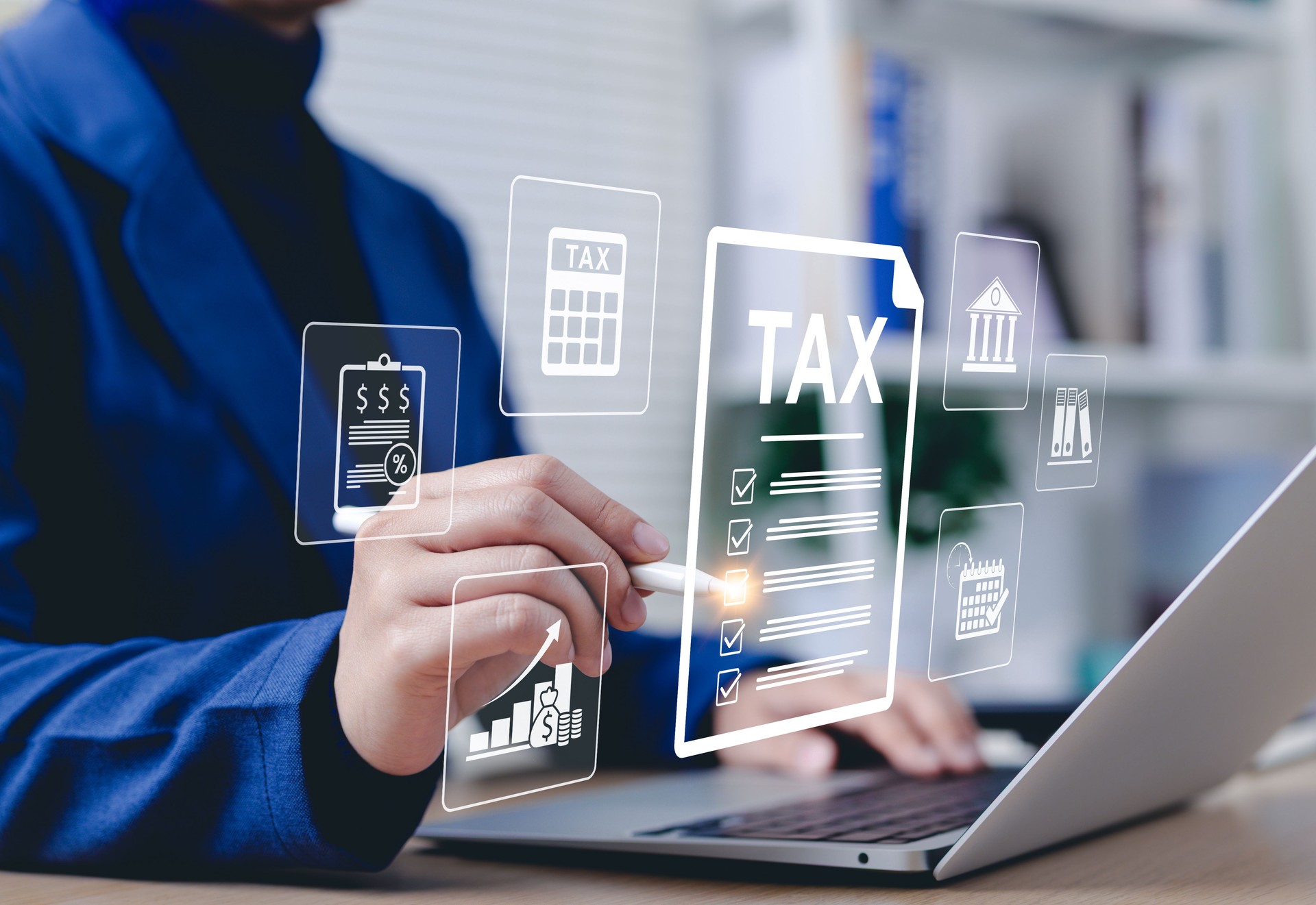 Tax Filing and Financial Management Concept. Businessperson using laptop with digital tax and finance icons, representing electronic tax filing, compliance, calculation, taxation, and fiscal planning.